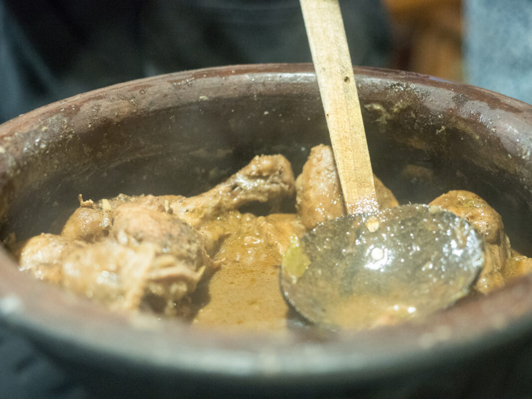 a large pot of sri lankan chicken drumstick curry in yellow sauce