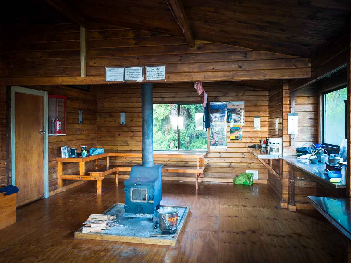 Wooden kitchen and bunks inside an Abel Tasman Great Walk hut