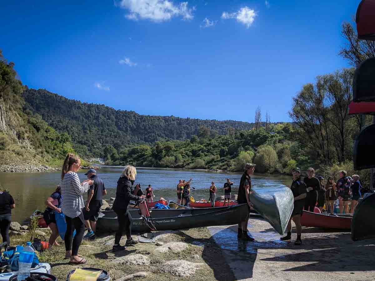 Group of friends launching canoes for the Whanganui River Journey