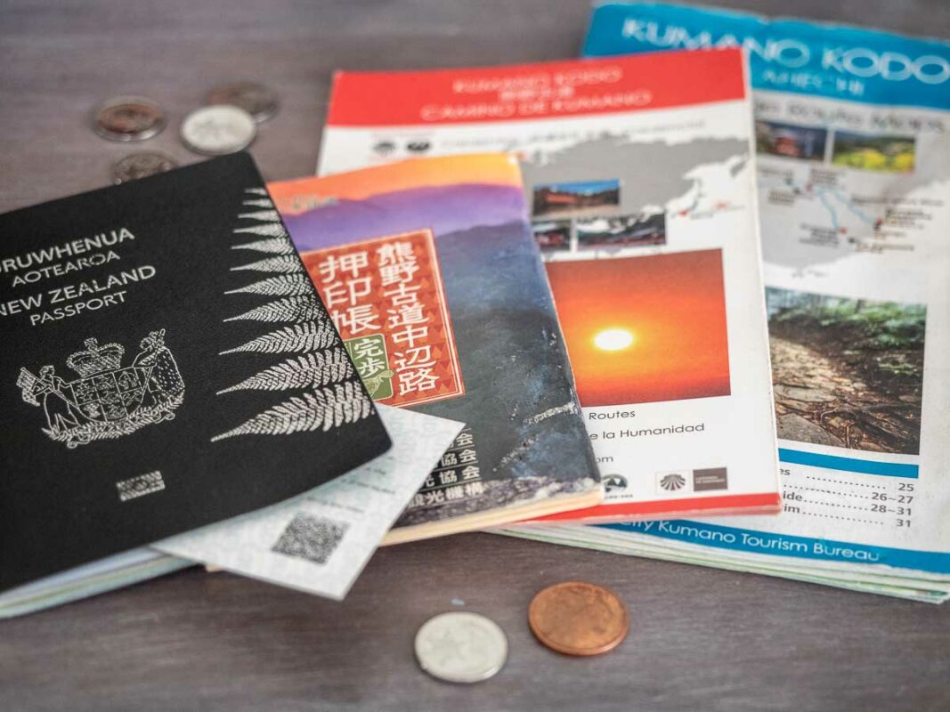Tristan Balme a pile of documents and maps for hiking the kumano kodo along with a passport and some japanese yen coins