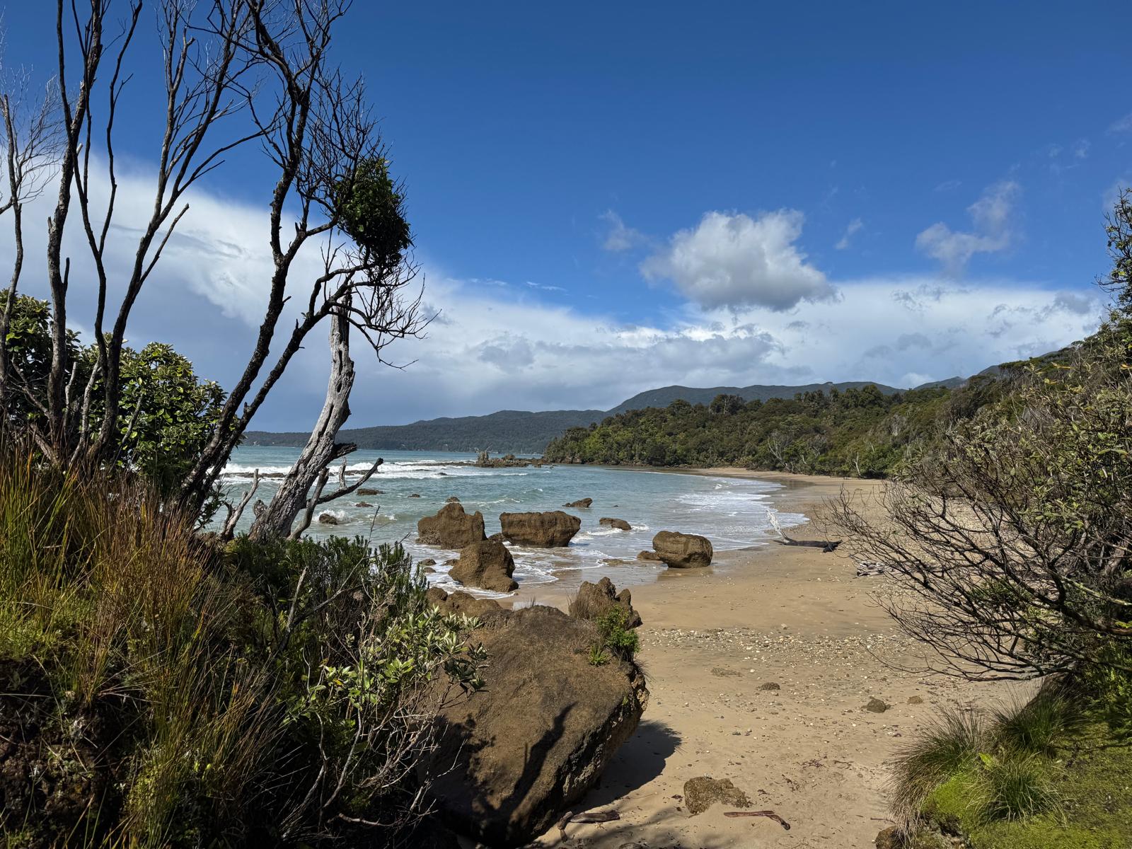 Rocky beach and blue water on the coastal section of the Hump Ridge Track