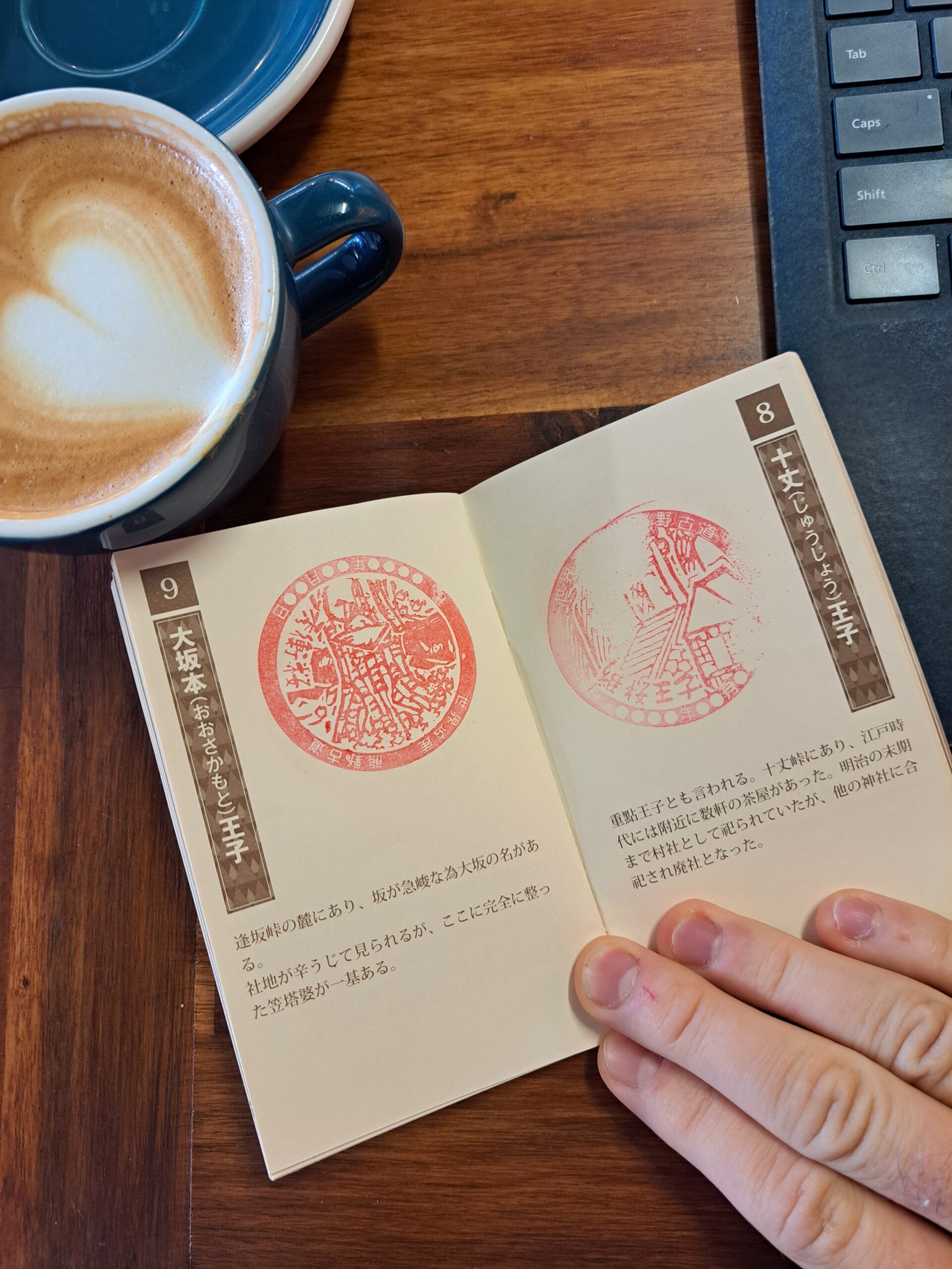Kumano Kodo pilgrim passport with red stamps beside a coffee